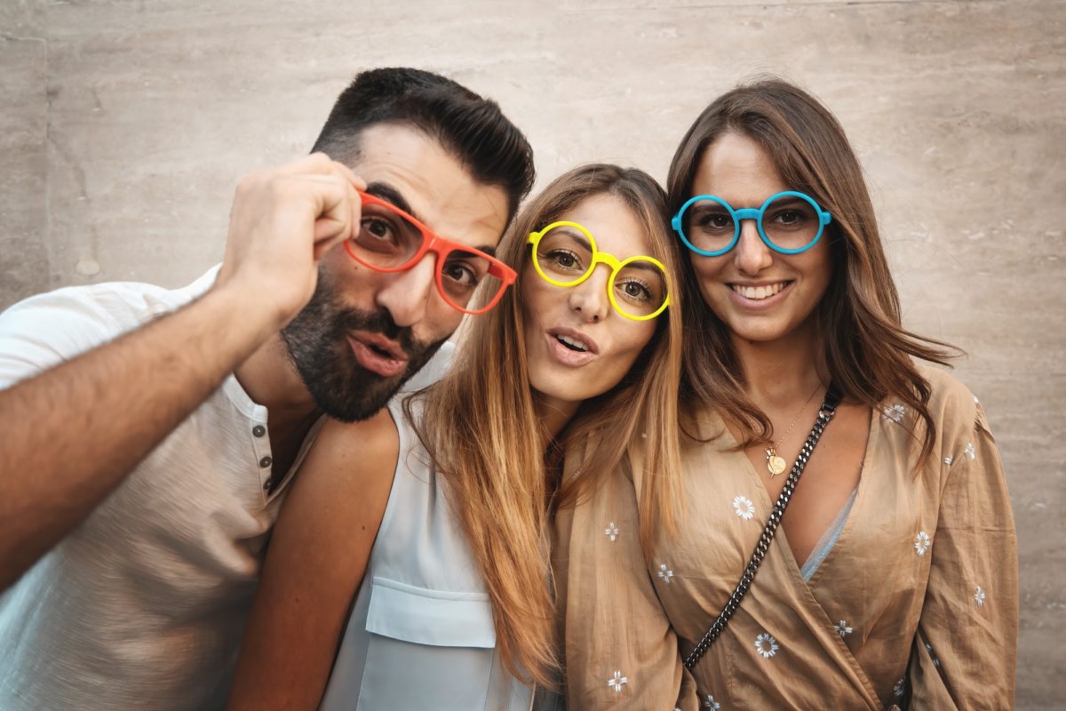 Friends looking at the camera with colorful eyeglasses